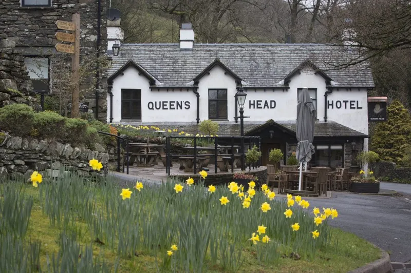 The Queen's Head Hotel exterior with daffodils in the foreground