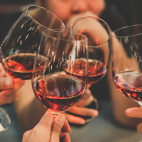 Group of friends toasting with glasses of red wine