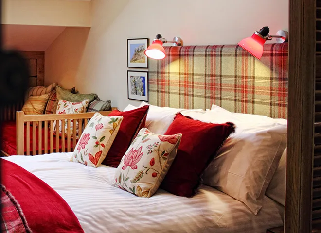 A bed which is mainly white, red and yellow. Lights are above the bed.