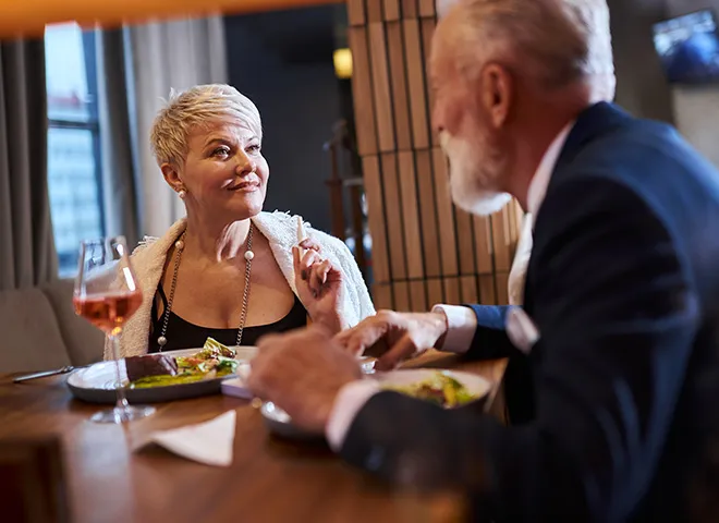 Man and woman talking over a table of food