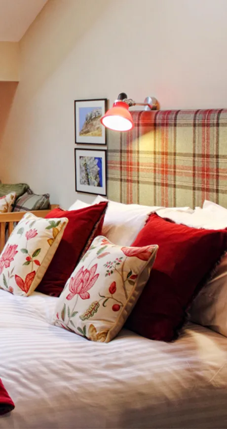 A bed which is mainly white, red and yellow. Lights are above the bed.