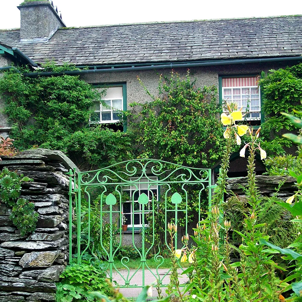 Ivy-clad Lake District cottage behind a green wrought iron gate