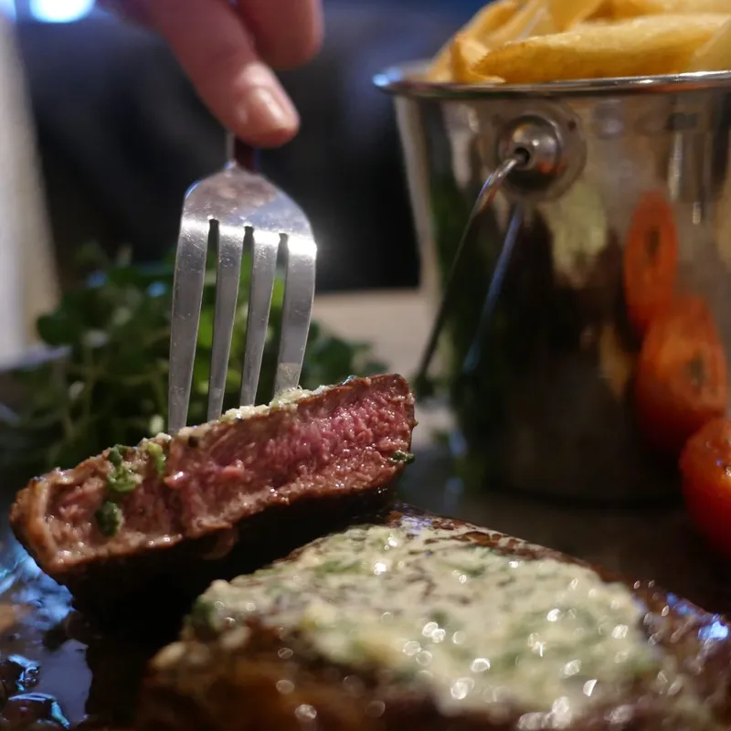 Sliced steak with herb butter and chips